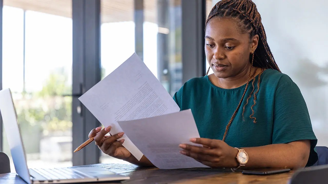 Consultant reviewing secondary approval documents at her desk.