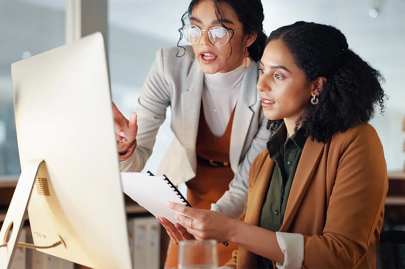 Two colleagues reviewing compliance documentation together.