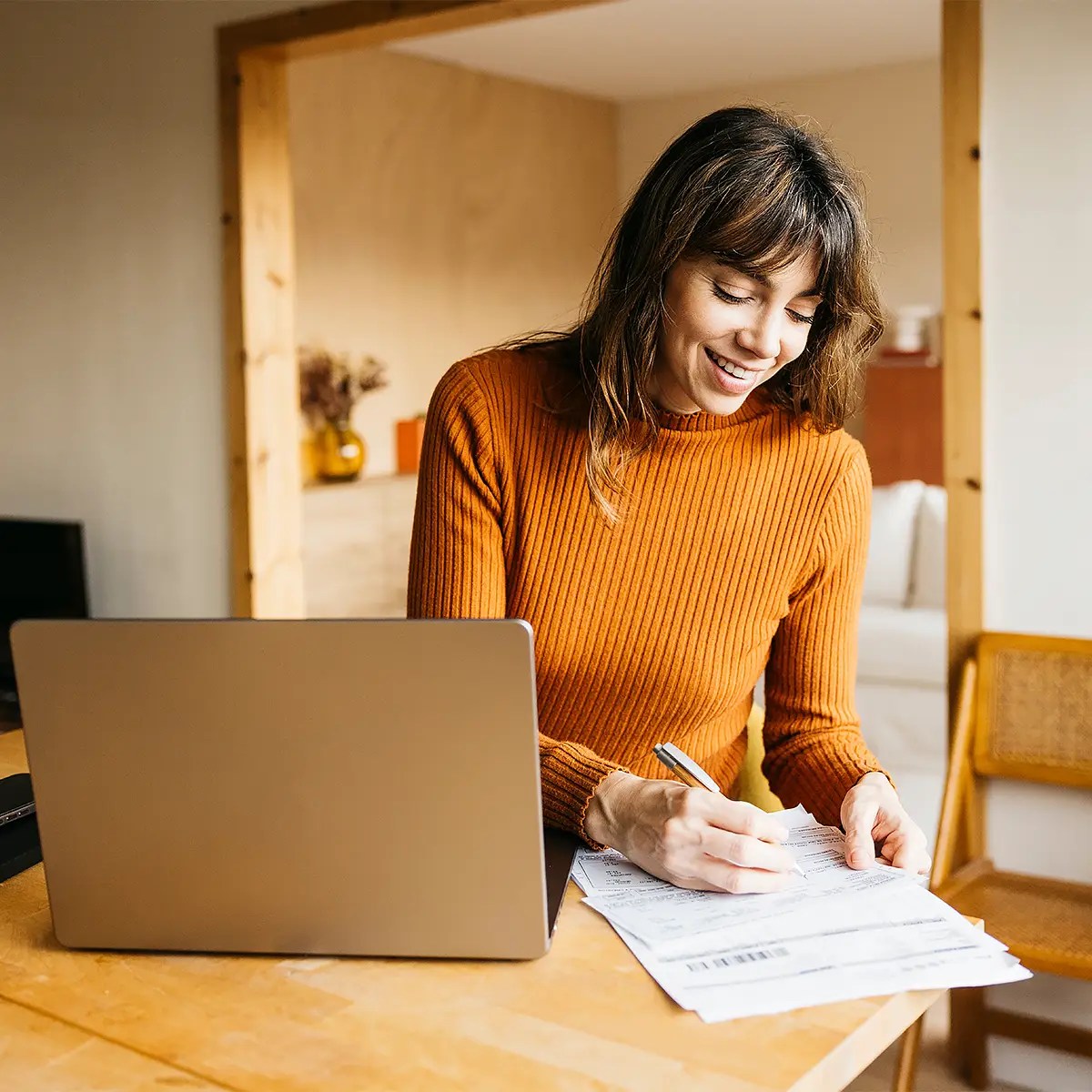 Woman reviewing state licensing paperwork at a laptop.