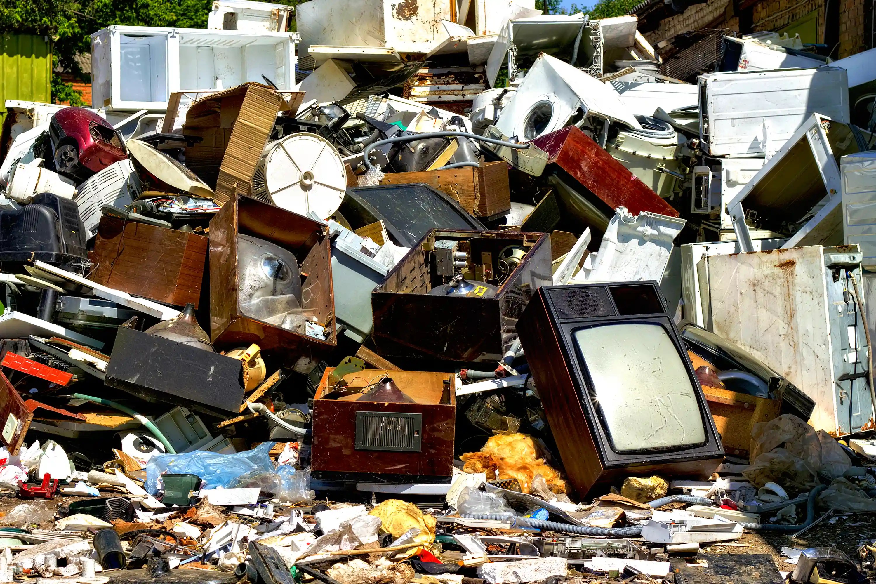 Stacked used and old electronics, televisions, and other appliances