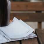 crop woman with notebook in park