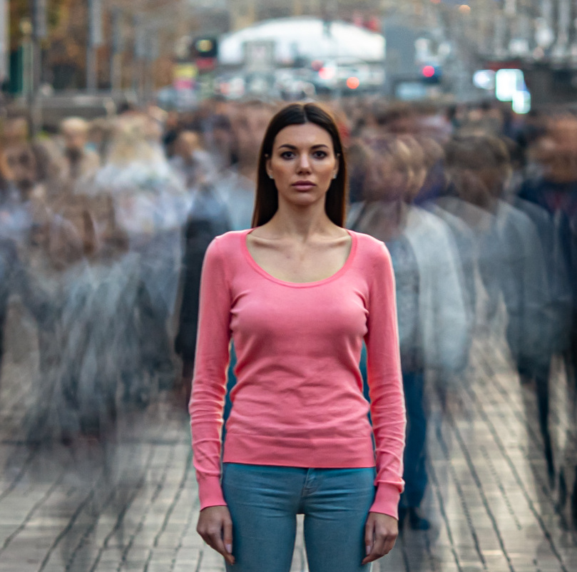 The young girl stands on the crowded urban street By realstock1