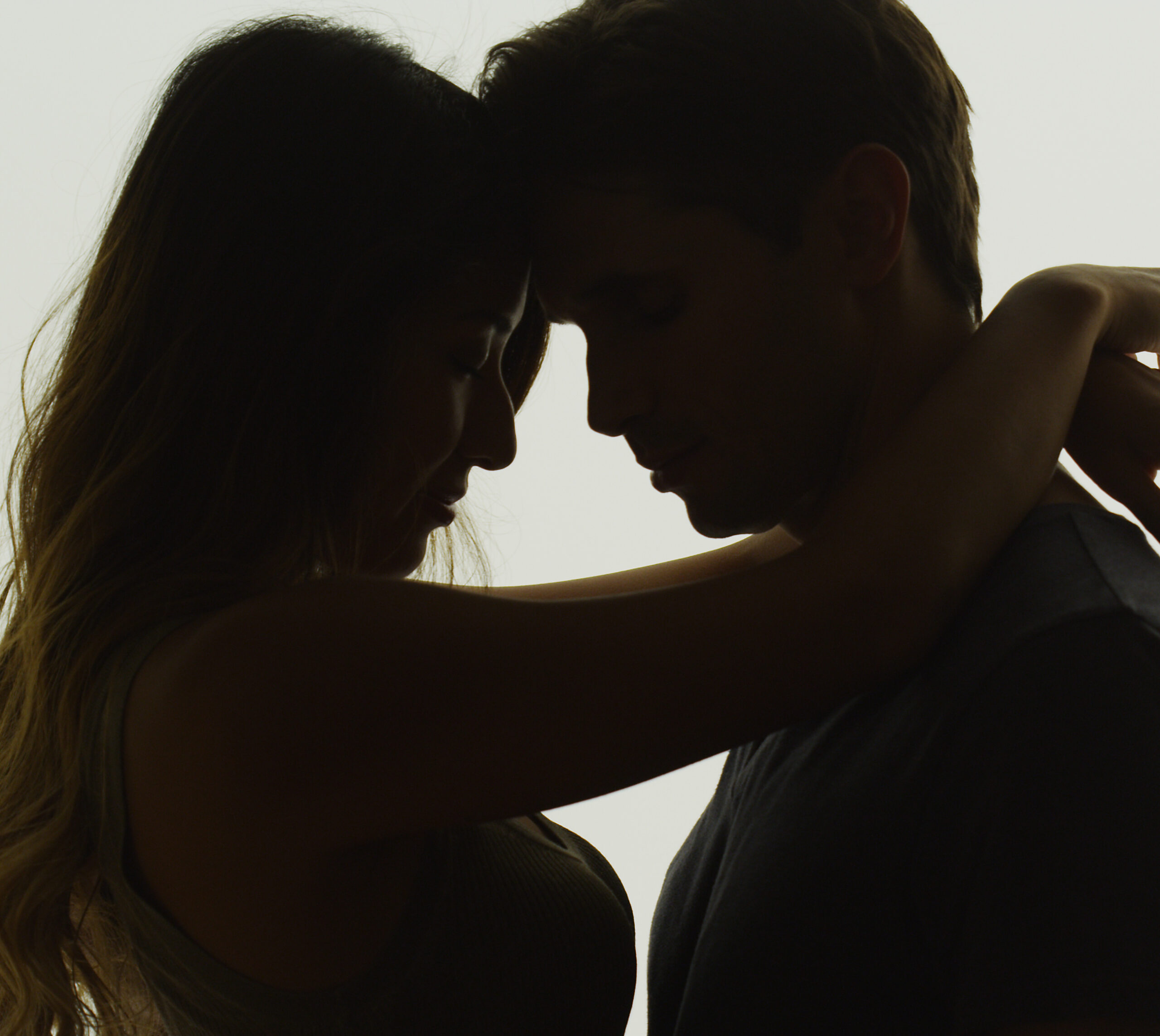 Interracial couple being intimate in front of window By rocketclips