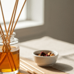 Natural reed diffuser with amber oil in a glass jar on a wooden table