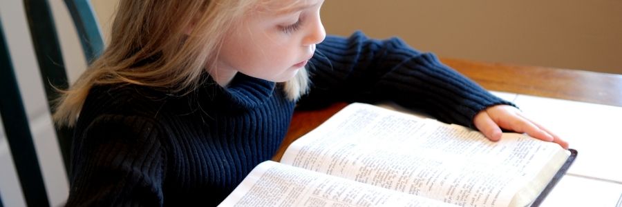 child reading a Bible