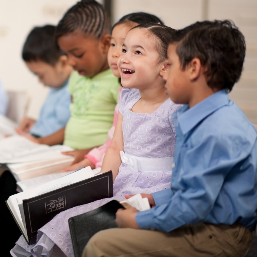 children at church opening Bibles
