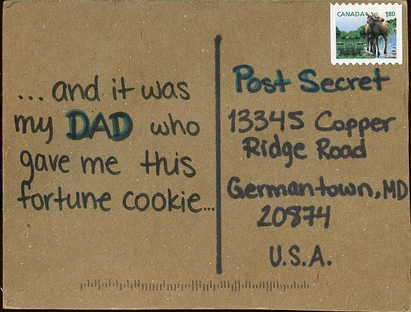 A handwritten note on a brown postcard with a stamp.