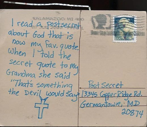 A handwritten note on a postcard with a simple cross illustration.