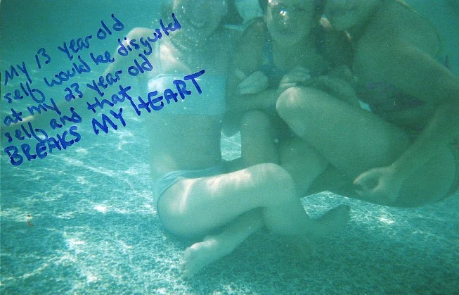 Underwater photo featuring three individuals with handwritten text in blue ink.