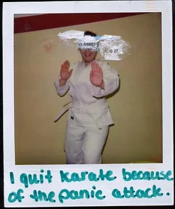 A person in a karate uniform poses with hands raised, smiling against a plain background.