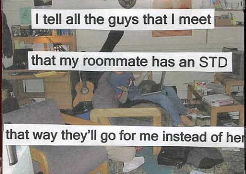 A cluttered room with a person sitting on a couch, using a laptop, and an acoustic guitar nearby.
