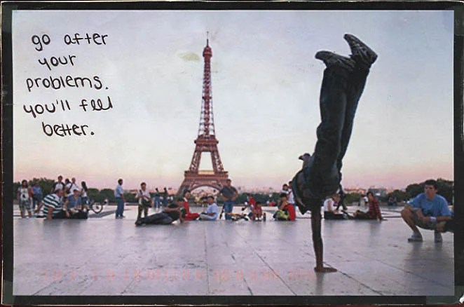 A vibrant photo capturing a handstand in front of the Eiffel Tower with people in the background.