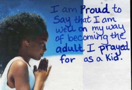 A profile of a child with curly hair, hands clasped in prayer, against a blue sky.