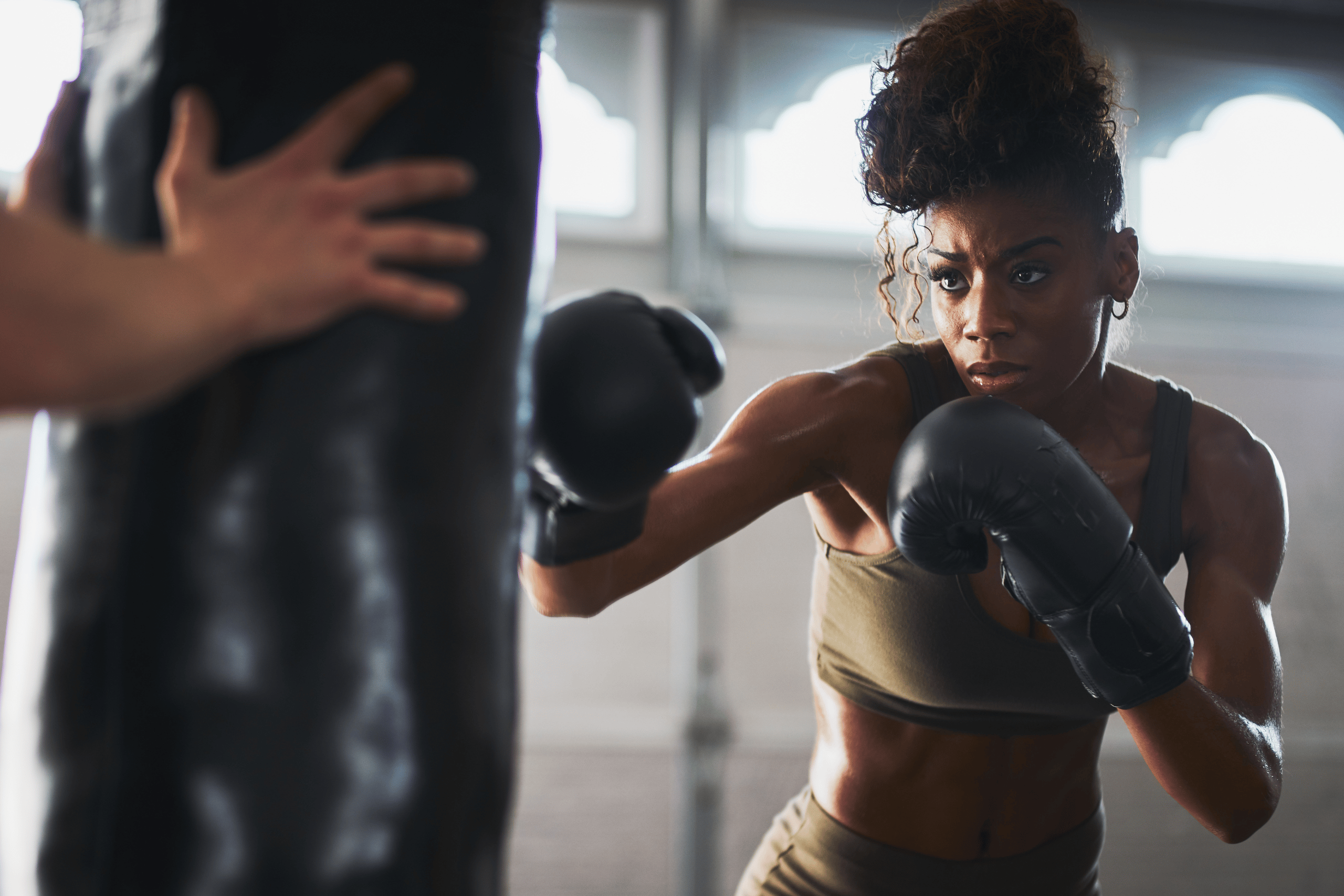 Woman in a fitness studio with boxing gloves, practicing self-defence