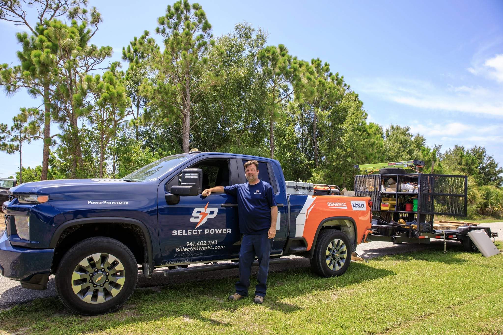 Tech standing in front of Select Power truck and trailer. 