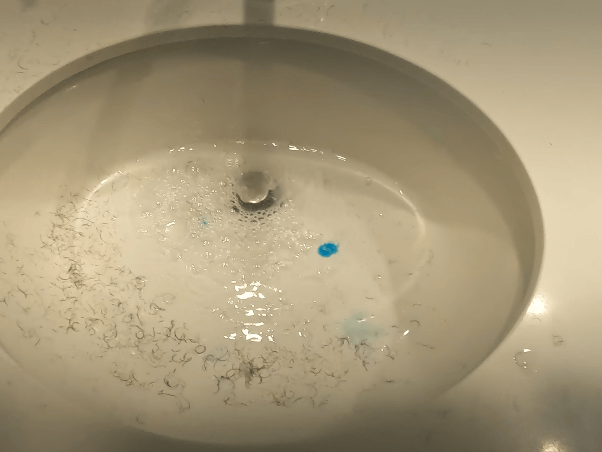 Standing water around a slow bathroom drain in the Sergeant Plumber media library