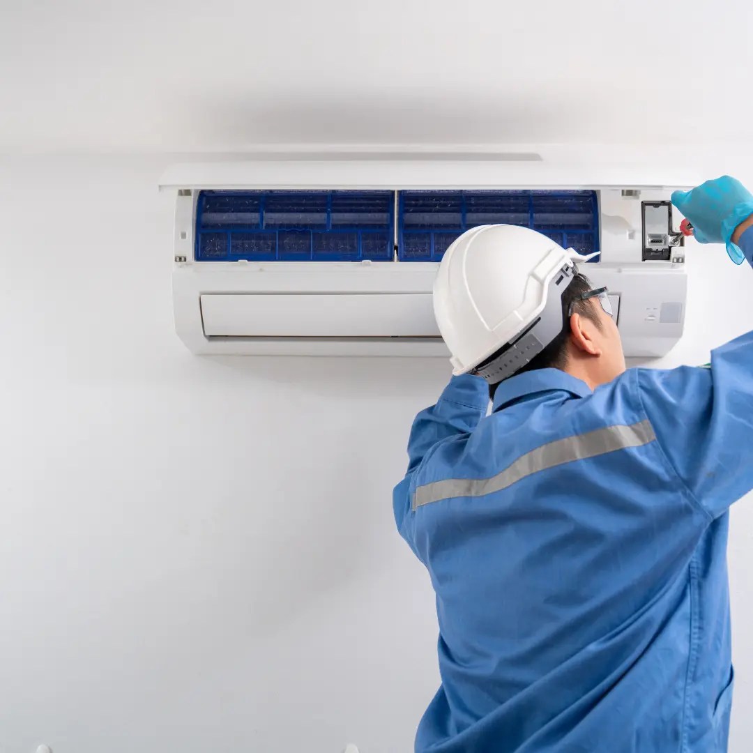 Un technicien qualifié répare une unité de climatisation.