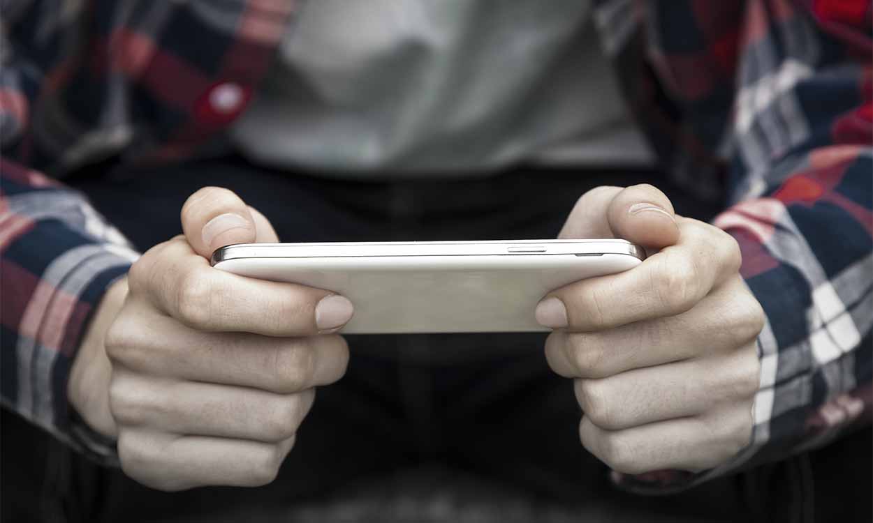 Imagem de adolescente segurando celular.