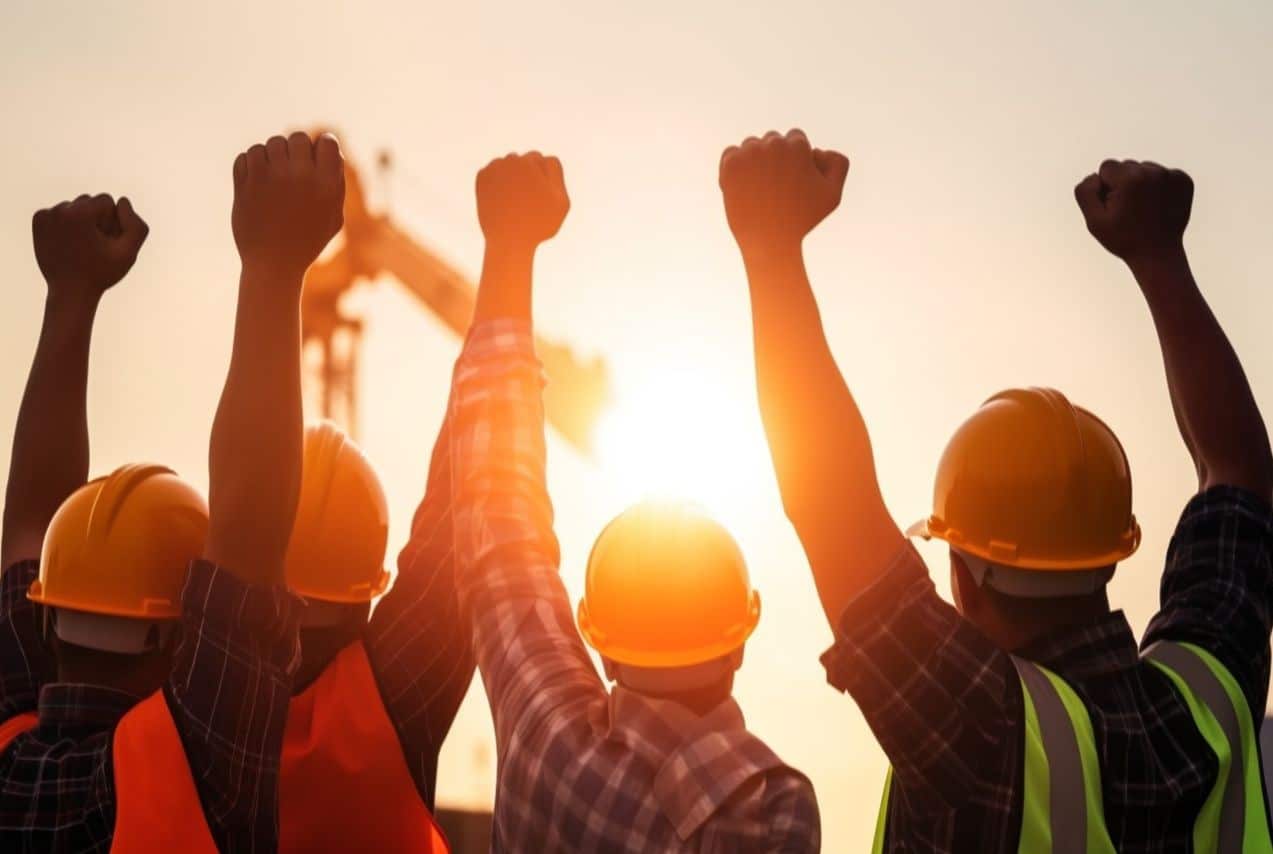 Trabalhadores com punhos no ar, comemorando o feriado