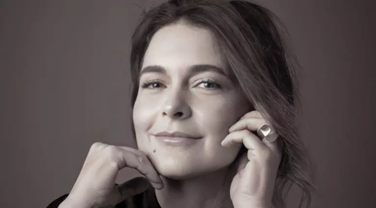 Foto da atriz Cláudia Abreu, vítima de golpe, com a mão no rosto.