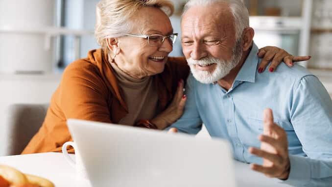 Casal de idosos conferindo reajuste valor de aposentadoria no computador