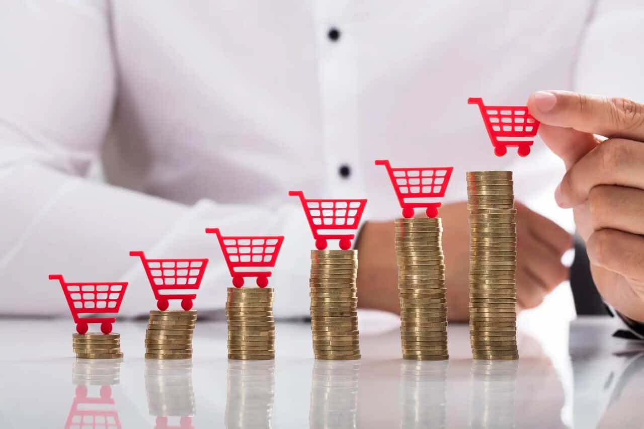 Pilha de moedas crescente com carrinhos de compra vermelhos em cima