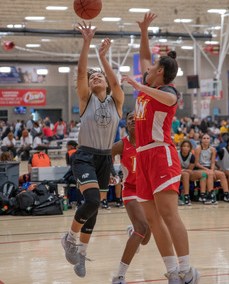 Girl shooting a basketball.