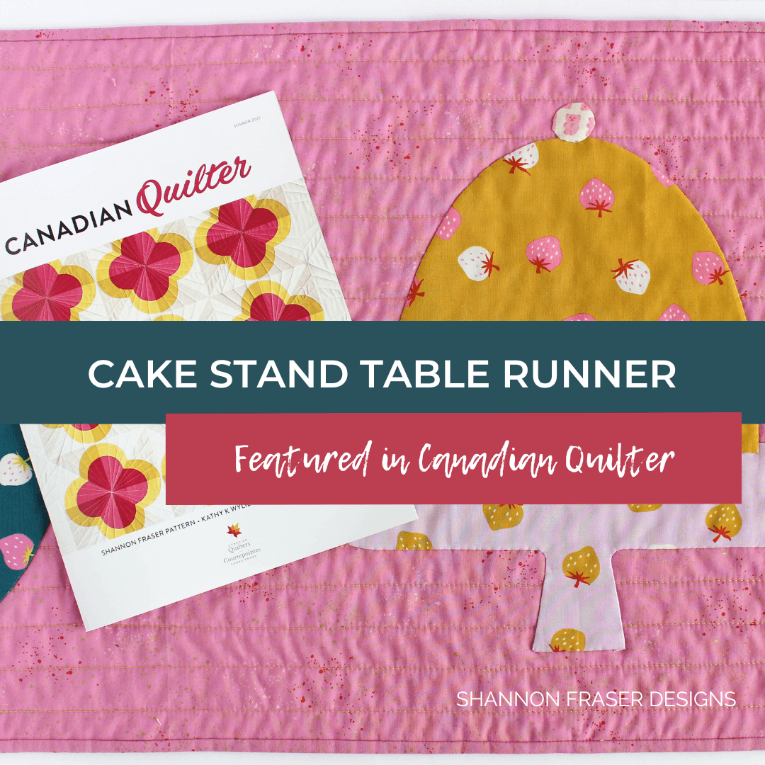 Brighten your table with the Cake Stand Quilted Table Runner from Shannon Fraser Designs, featured in Canadian Quilters Magazine! This table runner showcases beautiful appliqué—perfect for showing off your needle turn skills or making it quick with raw edge appliqué. A stylish handmade accent for any dining space or coffee table! #QuiltedTableRunner #AppliqueQuiltPattern #ModernQuiltDesign #CakeStandBlock