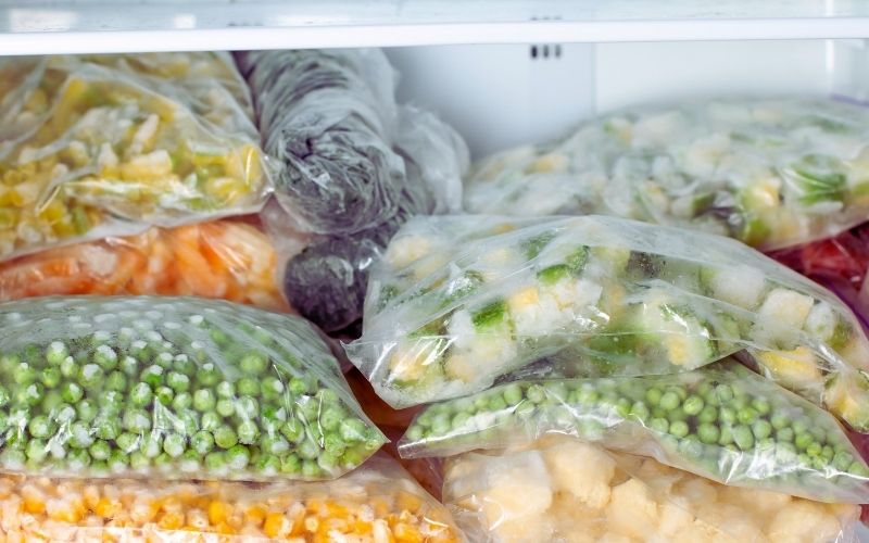 Frozen bags of veggies in a freezer