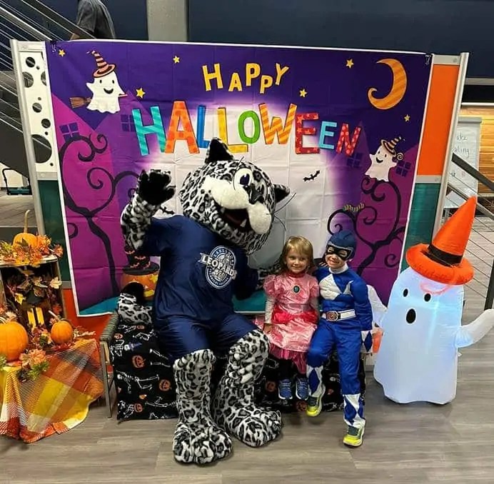 Lenny the Snow Leopard poses with children attending College, Candy, & Costumes in October 2024 at Lakeshore College. This year’s event will be held Oct. 18 in and around the Nierode building on Lakeshore’s Cleveland campus. Photo courtesy of Lakeshore College