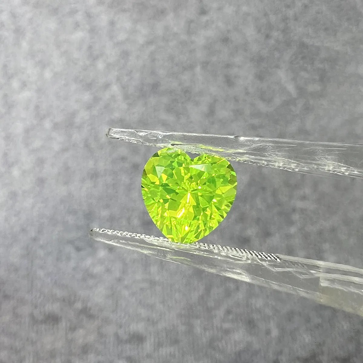 Heart cut LuAG loose gemstone glowing green lab grown crystal