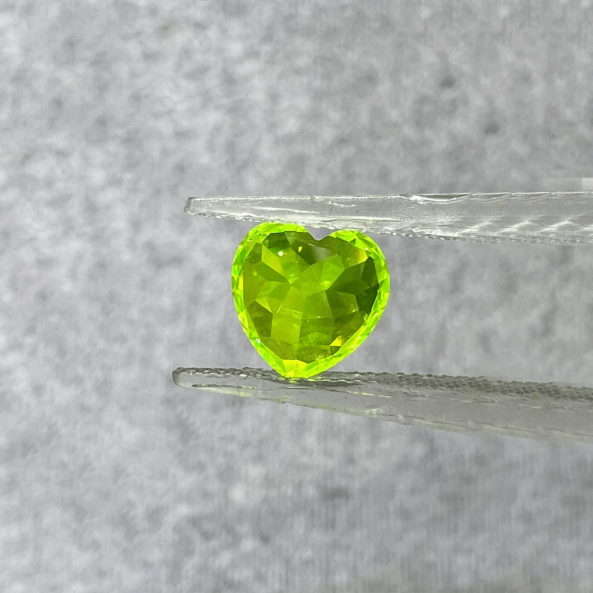 Heart cut LuAG loose gemstone glowing green lab grown crystal