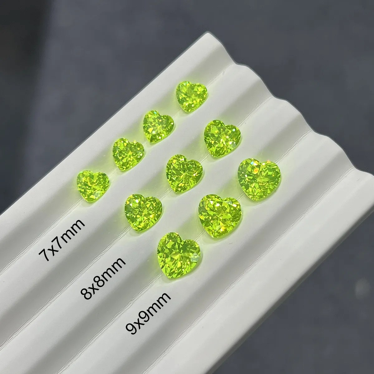 Heart cut LuAG loose gemstone glowing green lab grown crystal