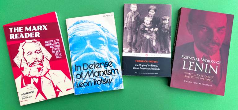 A photo of four books sitting on a green background. A Marx Reader, including Manifesto of the Communist Party, Wage, Labour, and Capital, and Value, Price, and Profit, by Karl Marx; In Defense of Marxism by Leon Trotsky; The Origin of the Family, Private Property and the State by Friedrich Engels; and the Essential Works of Lenin.