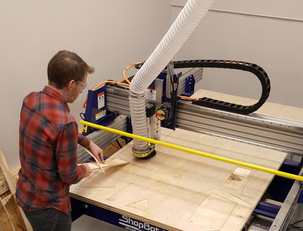 Person placing part on the CNC machine to assist hold-down process. 