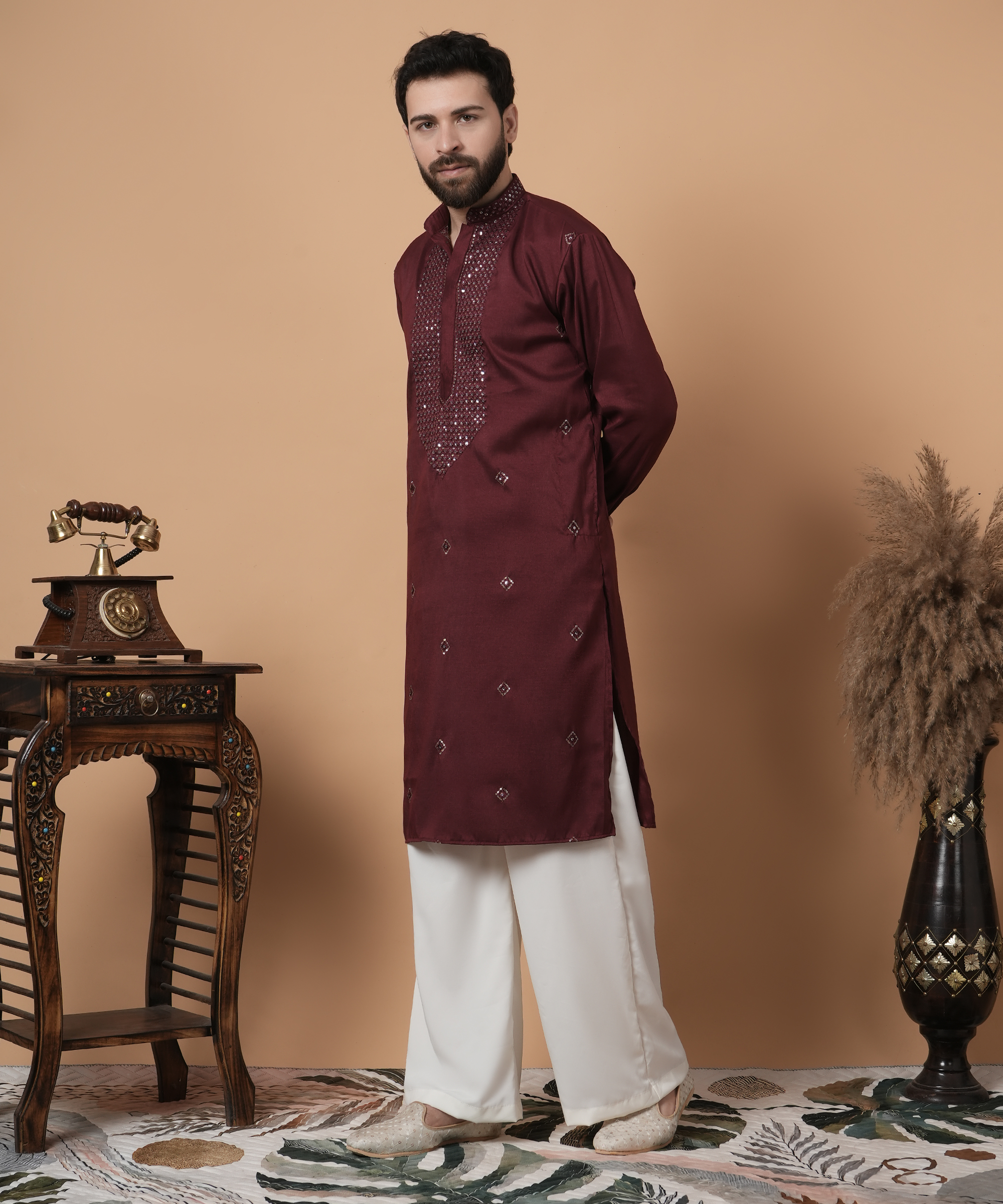 "Man wearing maroon silk kurta with sequin embroidered placket, paired with white palazzo pants and embroidered juttis, Shrobh Ethnic festive menswear"