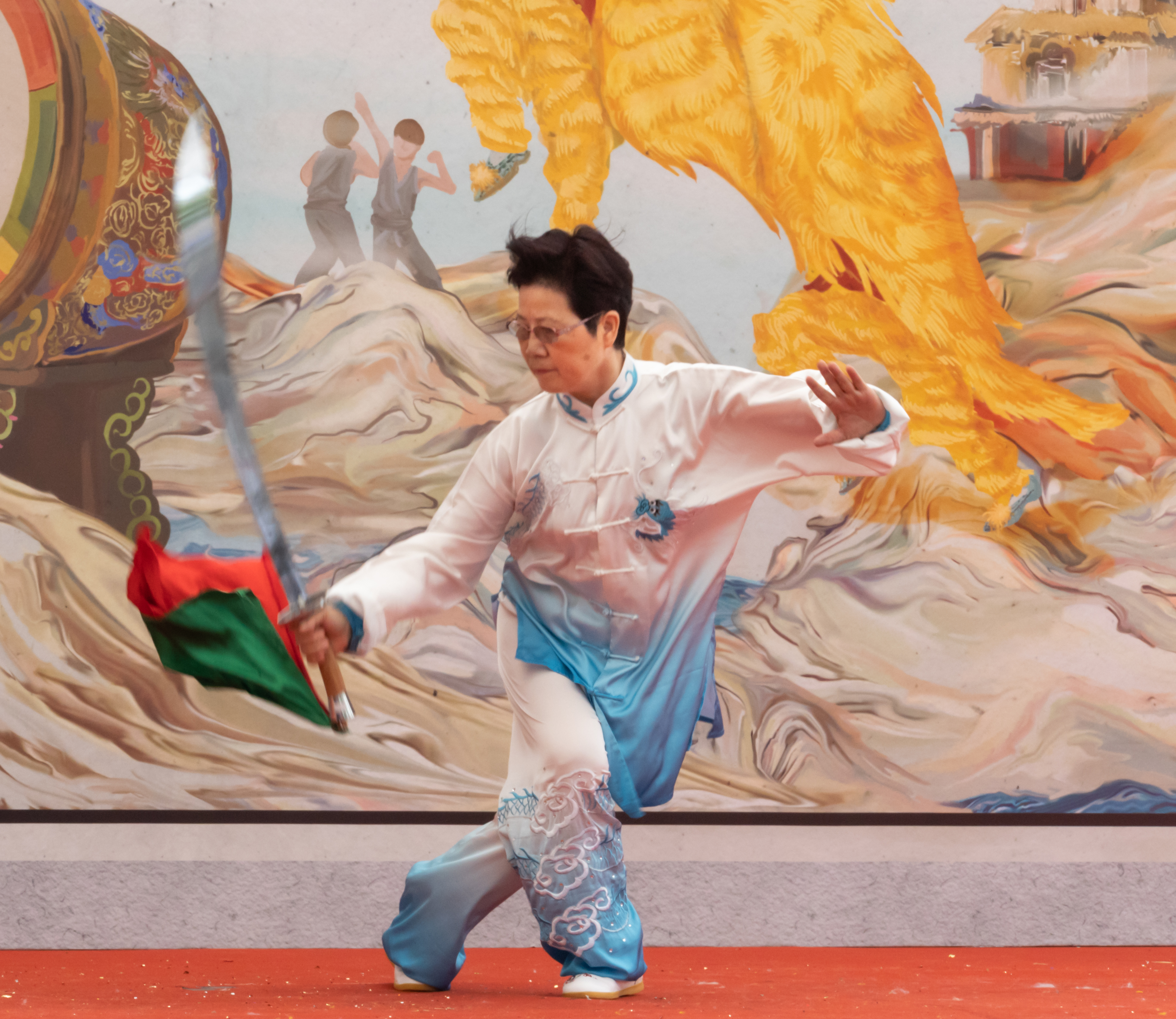 A woman performing a dance with traditional Chinese broadsword