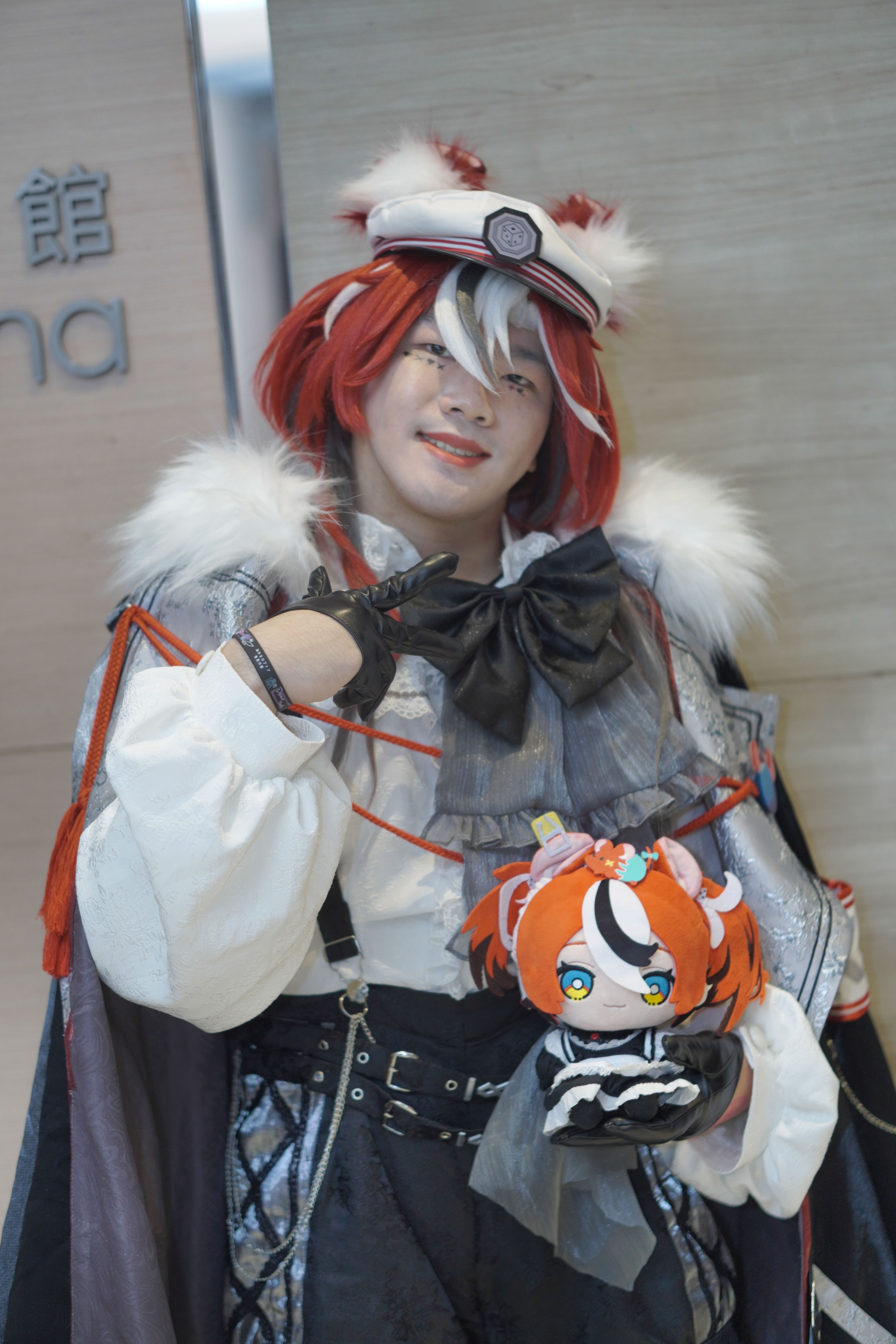 Jeff Tse in Hakos Baelz cosplay posing with a plushie, Sunday, March 30, 2025