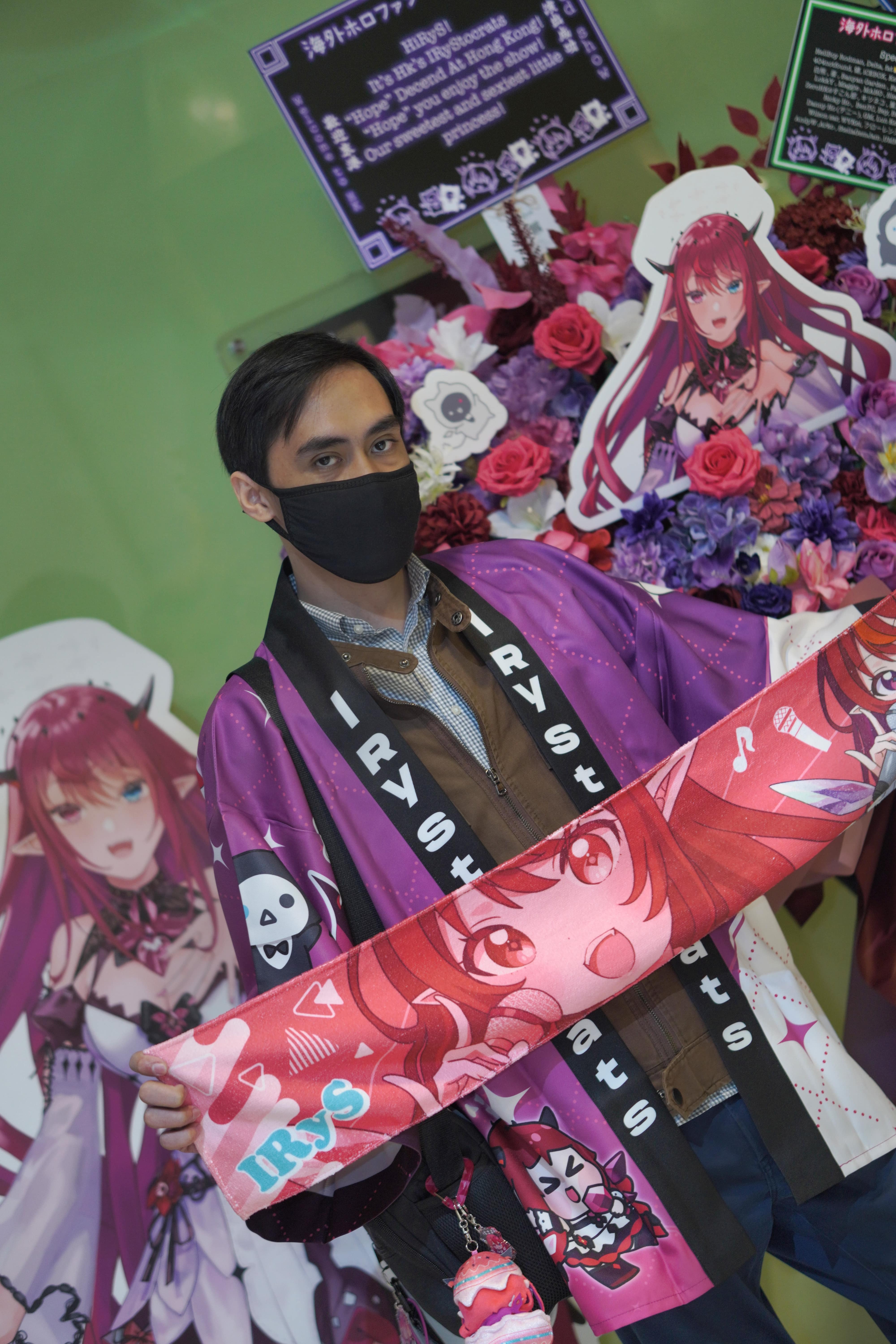 Sub Nil holding up a towel of IRyS in front of a flower basket placed by fans