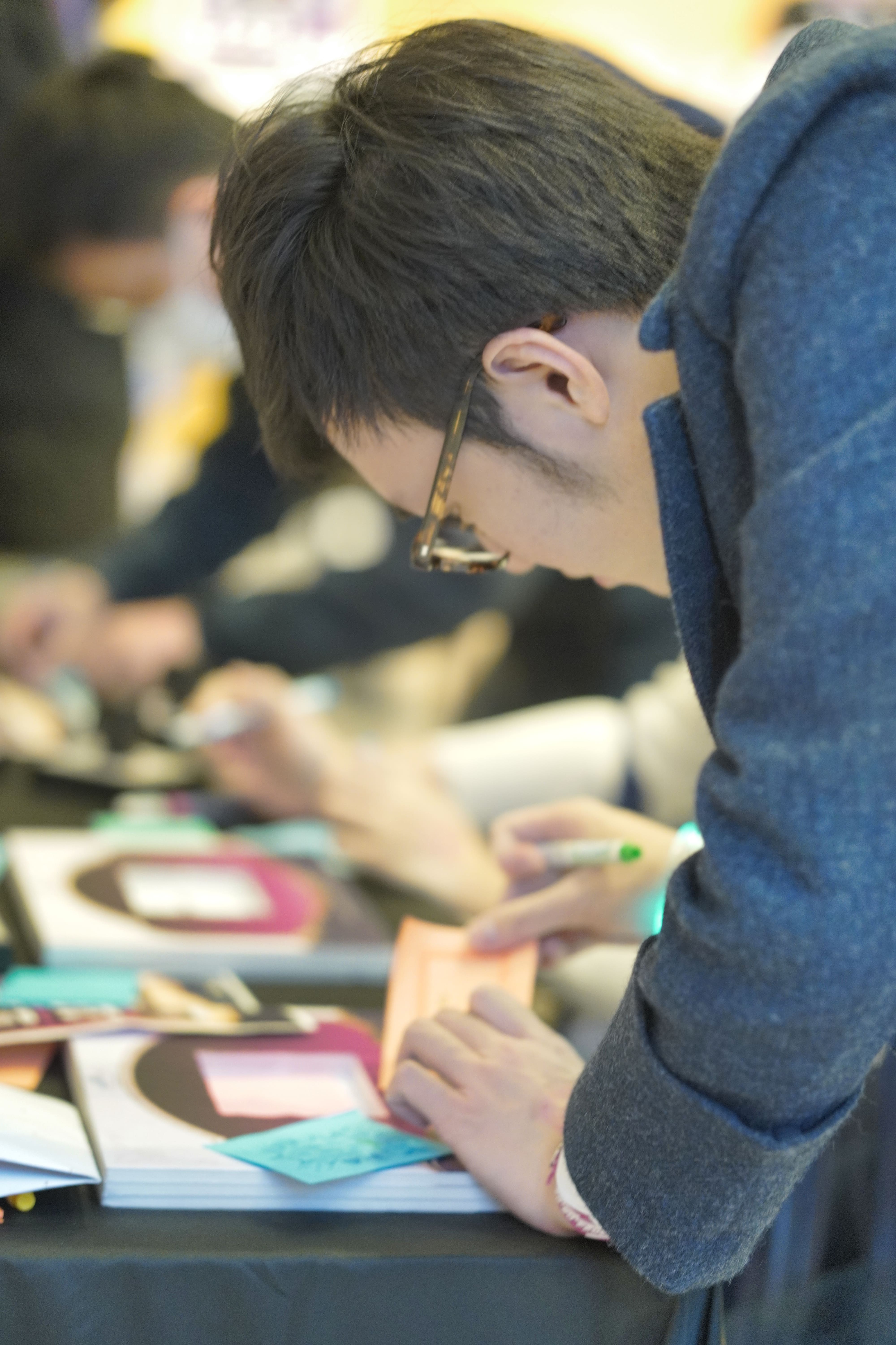 A fan writing a note to be posted on the venue board at the lobby of the event,