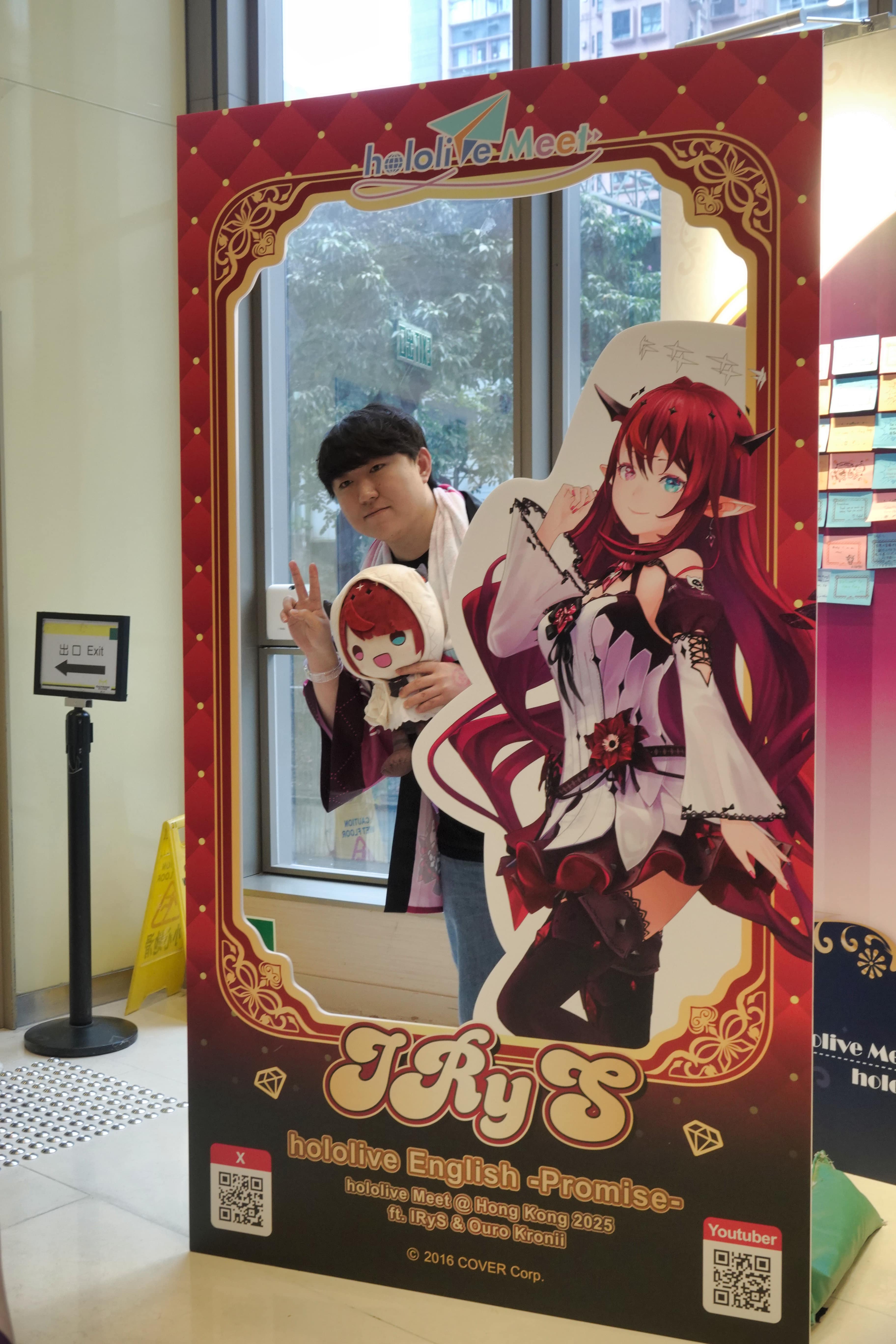 An IRyS fan posing with the cardboard cutout at the photo-taking spot