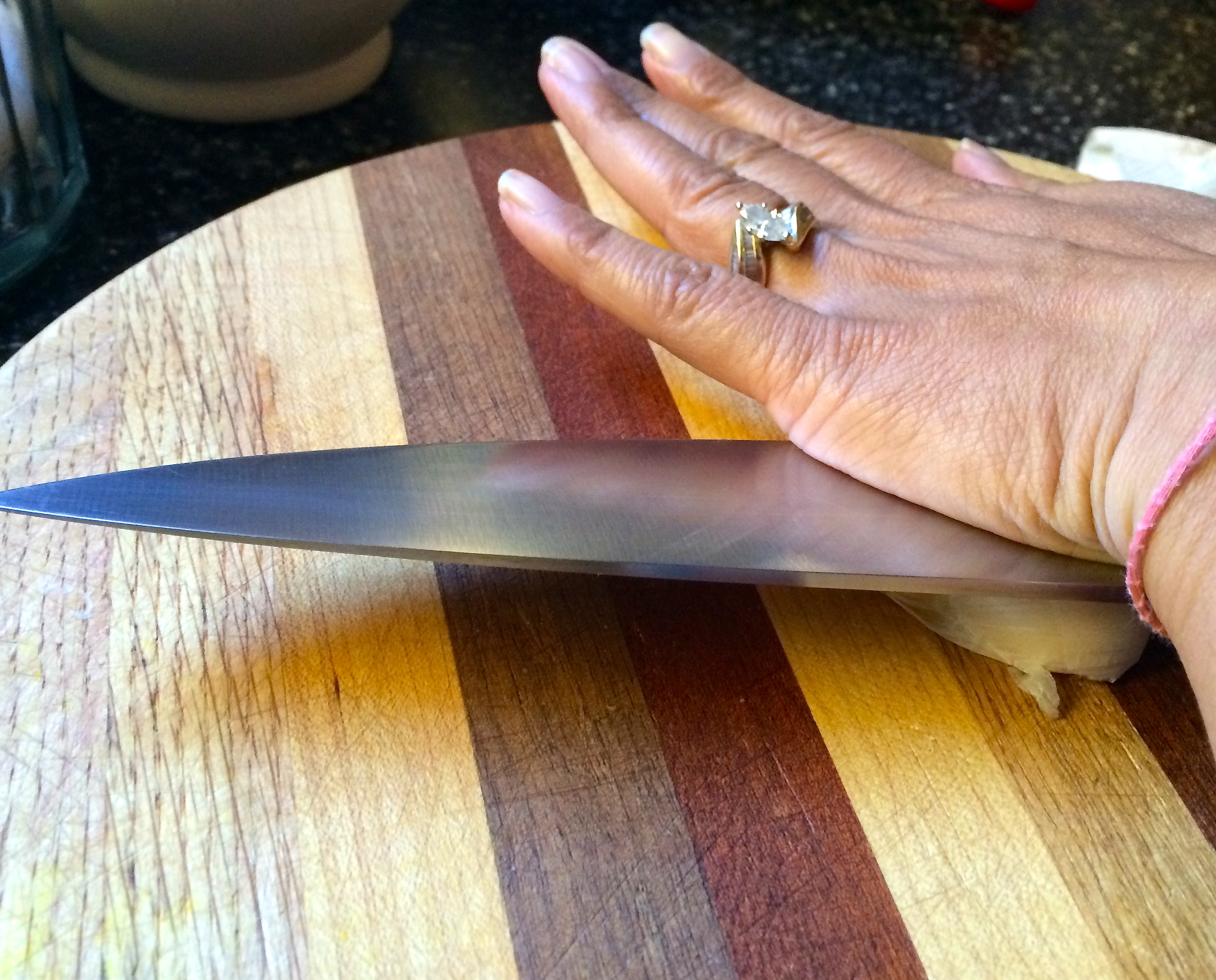 Chef's knife atop garlic clove