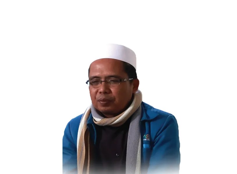 Potret seorang pria berkacamata mengenakan kopiah putih, syal, dan jaket biru dengan latar belakang putih.