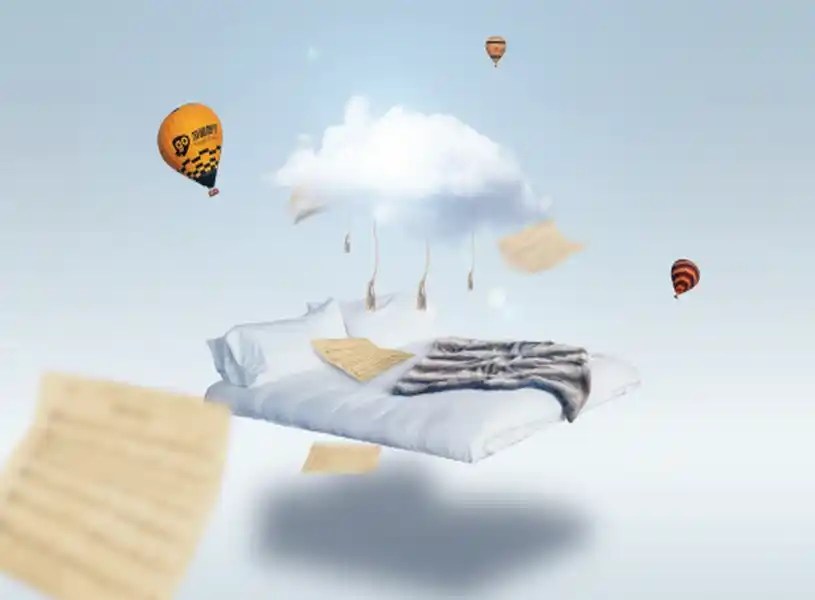 Tempat tidur melayang di atas awan dengan lembaran kertas dan balon udara