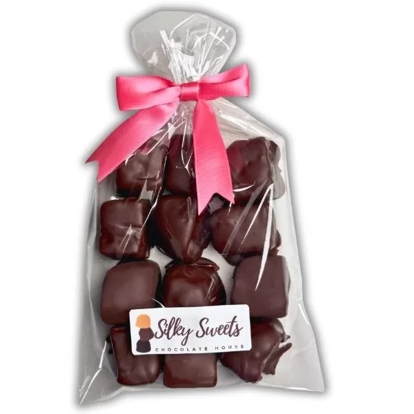 clear cellophane bag measuring 6x10in with 12 dark chocolate -covered marshmallows with a store label on the front that says silky sweets chocolate house and a pink bow to tie the bag
