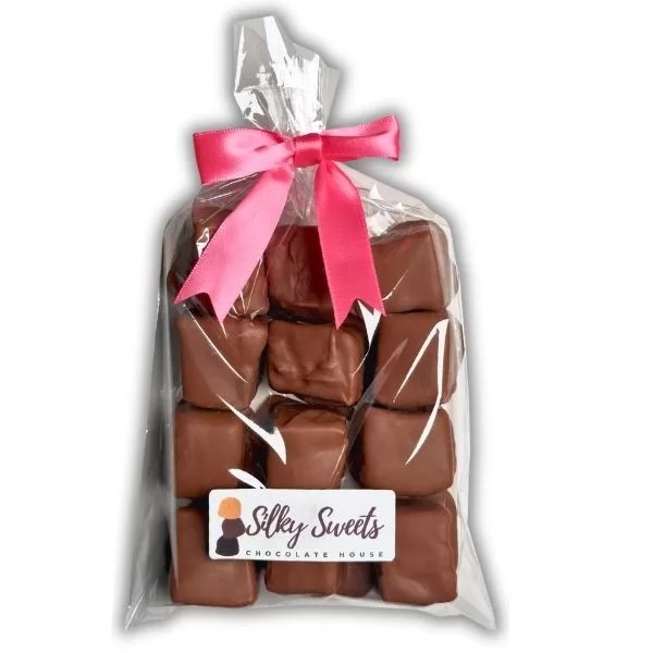 clear cellophane bag measuring 6x10in with 12 milk chocolate -covered marshmallows with a store label on the front that says silky sweets chocolate house and a pink bow to tie the bag