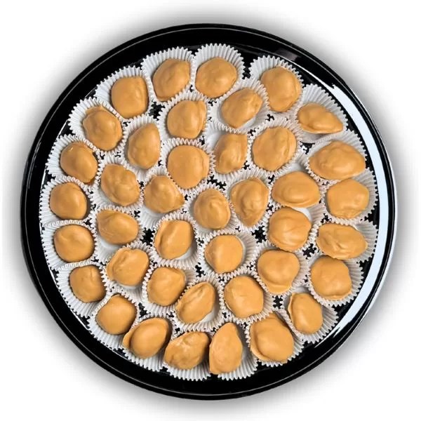 Photo of a black, round, plastic 12 in diameter catering plate with 40 blonde chocolate caramel nut clusters nestled in a white mini cupcake liner
