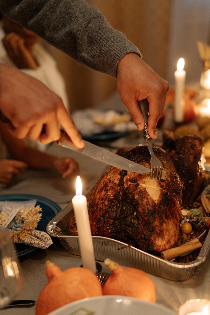 person slicing turkey during thanksgiving