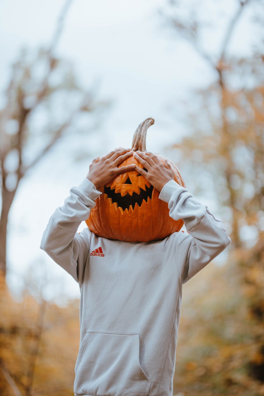 person with hand on pumpkin on head