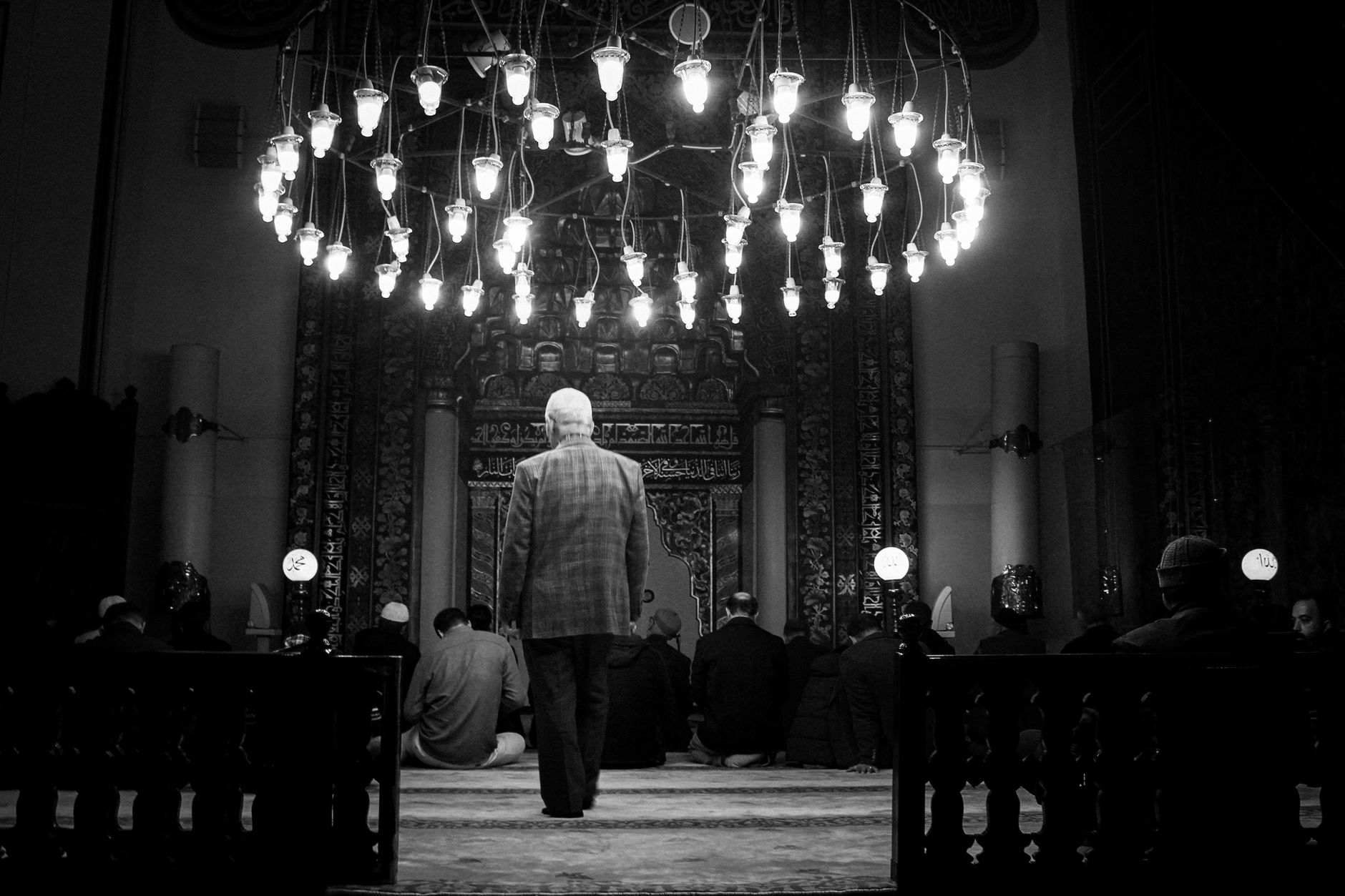 black and white image of prayer in mosque